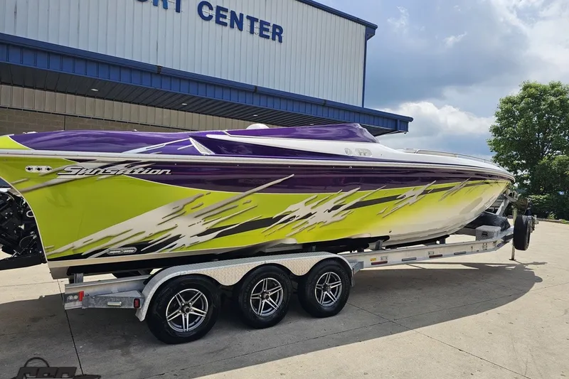 Slide: The Image of 2007 Sunsation 32 Dominator speedboat with vibrant purple and yellow design on a trailer. - 11