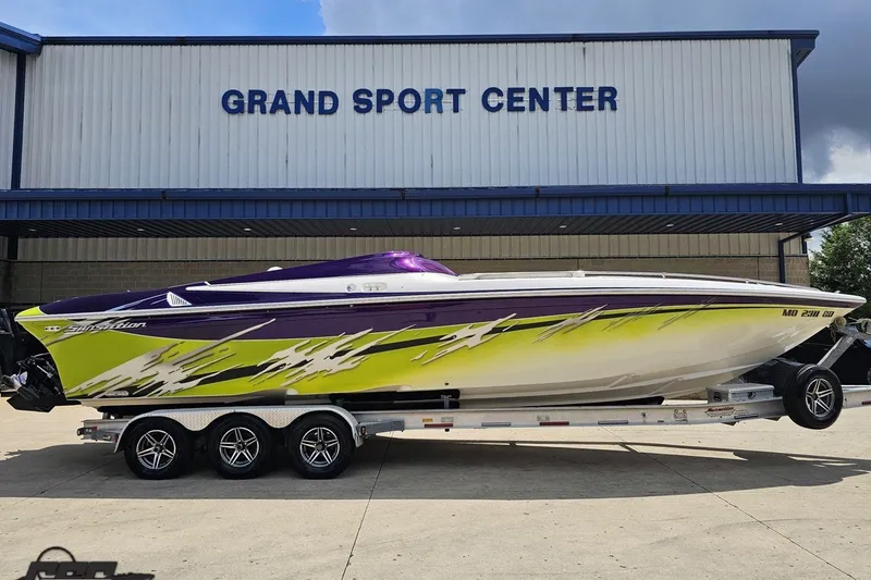 Slide: The Image of 2007 Sunsation 32 Dominator boat with vibrant graphics at Grand Sport Center. - 3