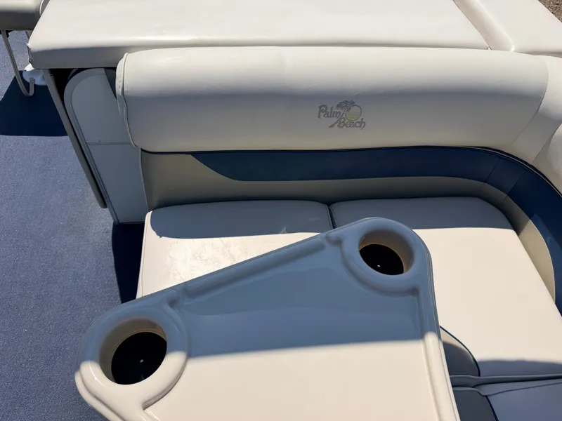 Slide: The Image of A white seating area on a boat with a table featuring cup holders. - 32