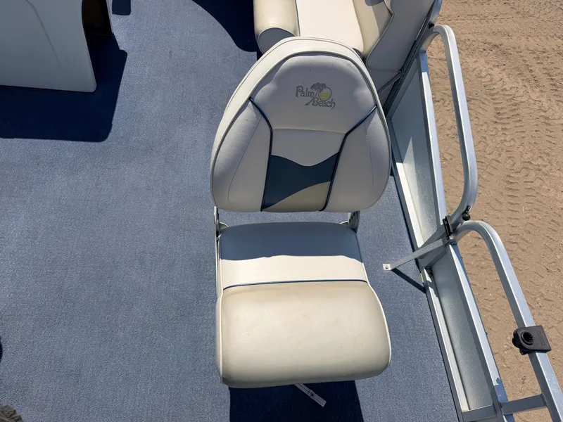 Slide: The Image of A white boat seat with Palm Beach logo on blue carpet flooring. - 12
