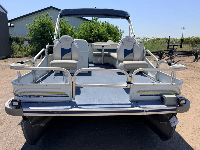 Slide: The Image of A 2004 Palm Beach pontoon boat with two seats and a blue canopy, parked in a yard. - 46