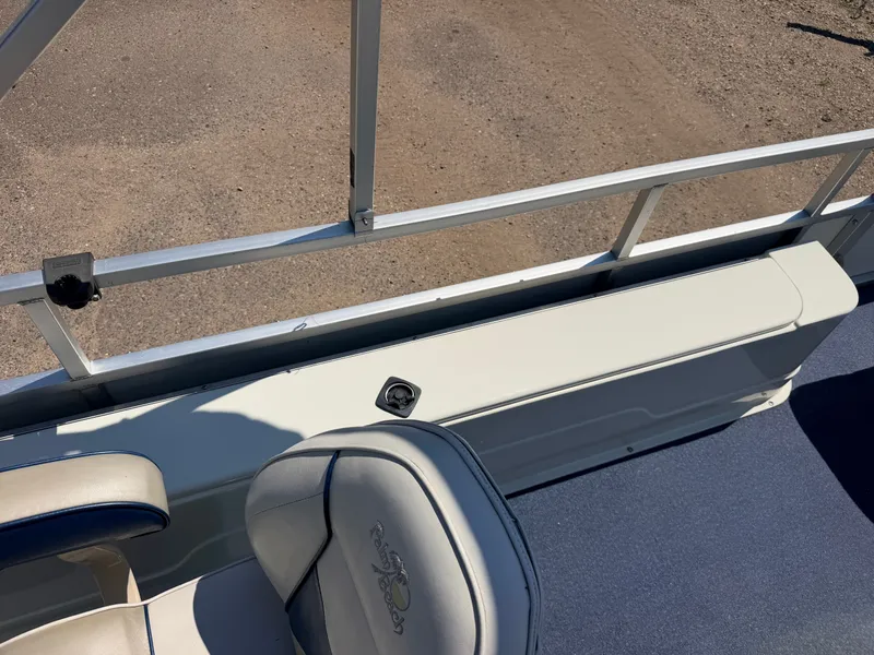 Slide: The Image of A boat with blue seats and a white railing on a sandy surface. - 26