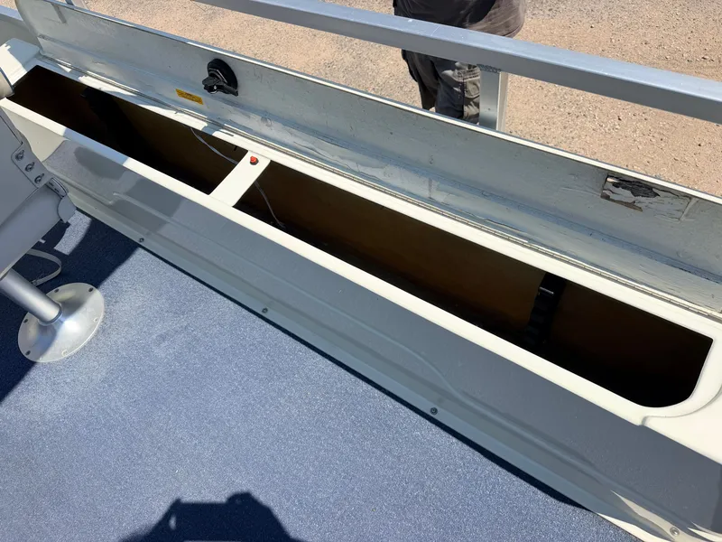 Slide: The Image of An open storage compartment on a boat with blue flooring and metal railing. - 27