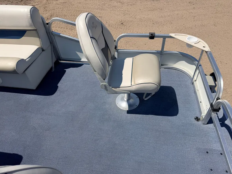 Slide: The Image of A boat with blue carpet flooring and white seats. It is situated on a sandy surface. - 11