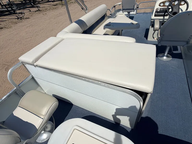 Slide: The Image of The image shows the deck of a 2004 Palm Beach 200 CastMaster boat with beige upholstery and a helm console. - 9