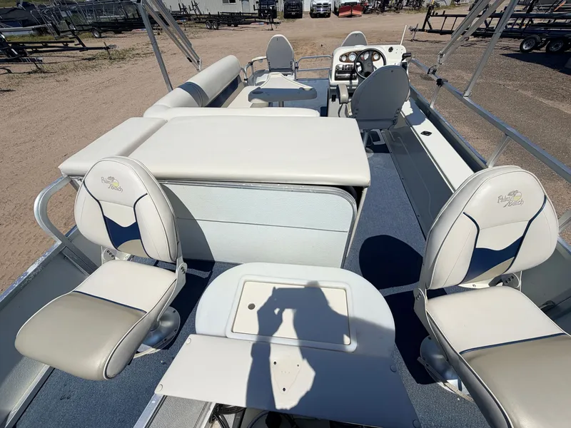 Slide: The Image of The image shows the deck of a 2004 Palm Beach 200 CastMaster boat with two swivel seats and a helm. - 8