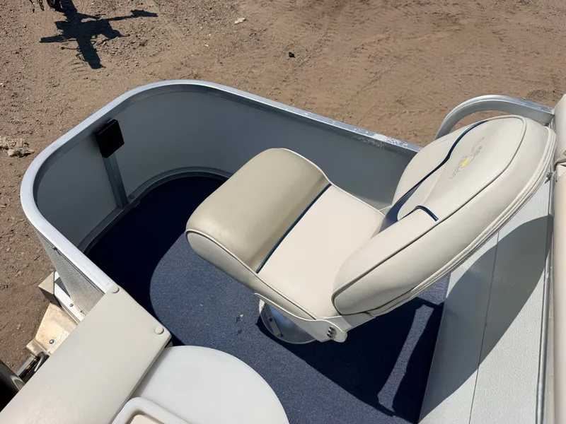 Slide: The Image of A beige boat seat on blue carpet, surrounded by a metal railing. - 43