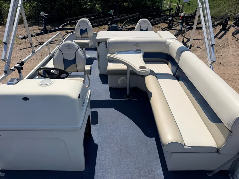 Slide: The Image of The image shows the interior of a 2004 Palm Beach 200 CastMaster boat with beige seating and a helm. - 5