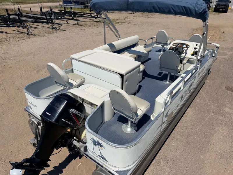 Slide: The Image of A 2004 Palm Beach pontoon boat with a 50HP Mercury 4Stroke engine, featuring seating and a sunshade. - 7