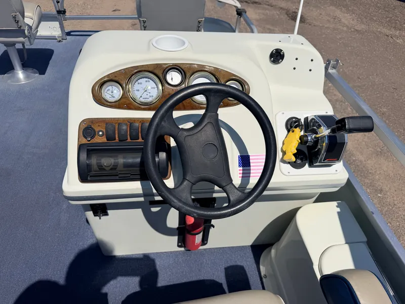 Slide: The Image of The image shows a boat's helm with a black steering wheel and various instruments. - 23