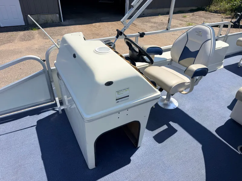 Slide: The Image of The image shows the helm of a 2004 Palm Beach 200 CastMaster boat with a comfortable seat. - 20