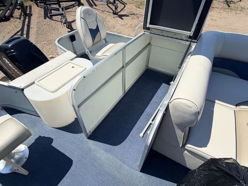 Slide: The Image of Interior view of a 2004 Palm Beach 200 CastMaster boat with seating and storage space. - 36