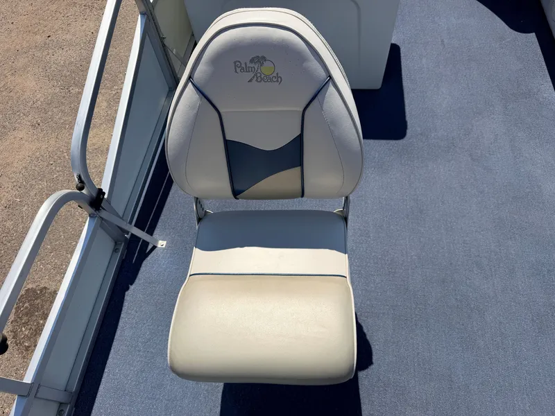 Slide: The Image of A white boat seat with Palm Beach logo on blue carpet flooring. - 16