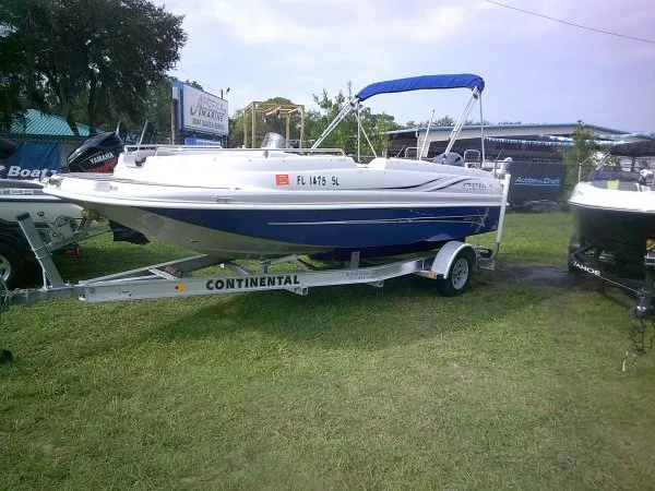 Slide: The Image of A white and blue 2019 Starcraft Allstar 1915 boat on a Continental trailer on grass. - 1