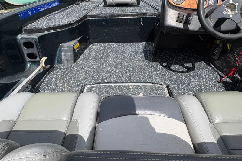 Slide: The Image of Interior of a 1998 Triton Tr-17 boat with gray seating and steering wheel. - 18