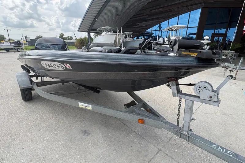 Slide: The Image of 1998 Triton Tr-17 boat on trailer, parked outdoors near a modern building. - 9