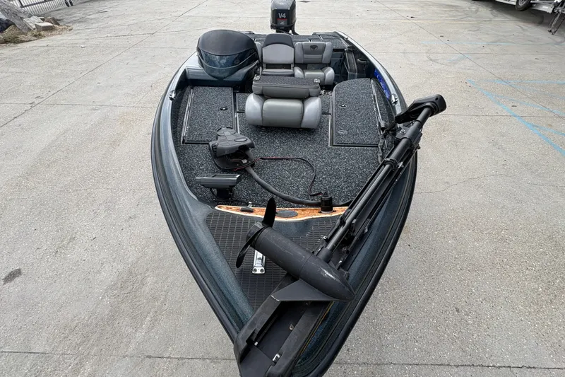 Slide: The Image of 1998 Triton Tr-17 boat with seating and motor, parked on concrete surface. - 10