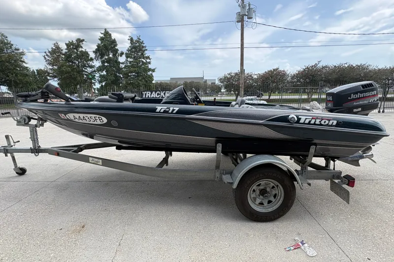 Slide: The Image of 1998 Triton Tr-17 boat on trailer with Johnson V4 engine, parked outdoors. - 6