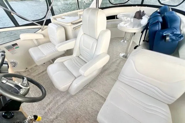 Slide: The Image of Interior of 2004 Carver 420 Mariner yacht with plush white seating and helm. - 11