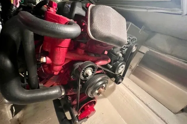 Slide: The Image of Engine of a 2004 Carver 420 Mariner, showcasing red components and black hoses. - 43