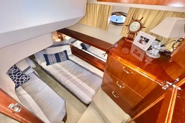 Slide: The Image of Luxurious cabin interior of 2004 Carver 420 Mariner yacht with twin beds and wooden cabinetry. - 25