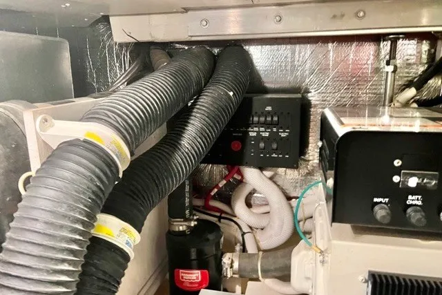 Slide: The Image of Engine room of a 2004 Carver 420 Mariner with hoses and control panel. - 33