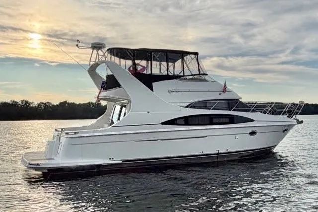 Slide: The Image of 2004 Carver 420 Mariner yacht on calm water at sunset. - 4