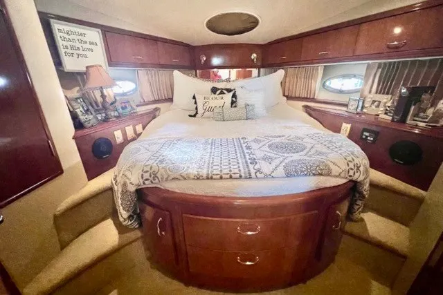 Slide: The Image of Luxurious 2004 Carver 420 Mariner yacht bedroom with elegant wood cabinetry and cozy bedding. - 23