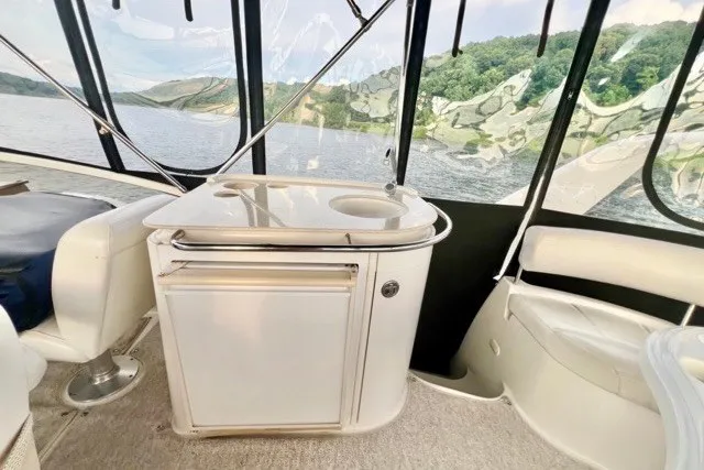 Slide: The Image of Interior of 2004 Carver 420 Mariner yacht with seating and kitchenette, overlooking scenic water view. - 10