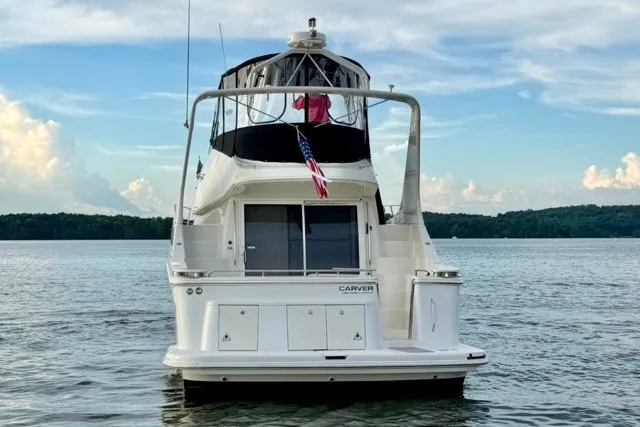Slide: The Image of 2004 Carver 420 Mariner yacht on serene lake with American flag. - 5