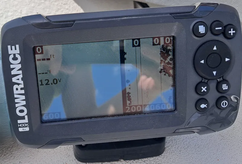 Slide: The Image of A Lowrance fish finder displays a depth of 0 feet and a voltage of 12.0V. - 27