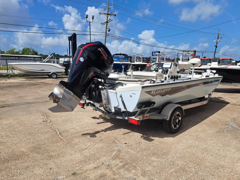 Slide: The Image of A 2022 Ranger RB190 boat on a trailer with an outboard motor, parked in a marina area. - 8