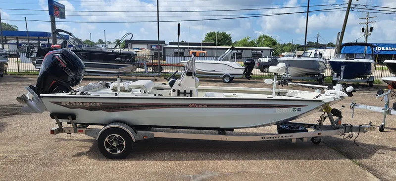 Slide: The Image of A 2022 Ranger RB190 boat on a trailer, parked on a concrete lot with other boats in the background. - 7