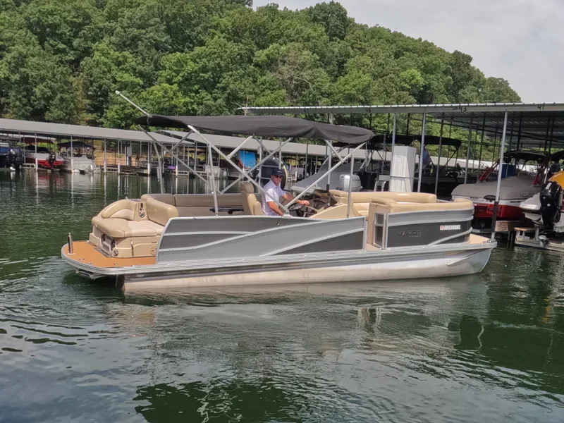 Slide: The Image of A 2013 Harris Grand Mariner 250 SEL pontoon boat cruising on a calm lake. - 4