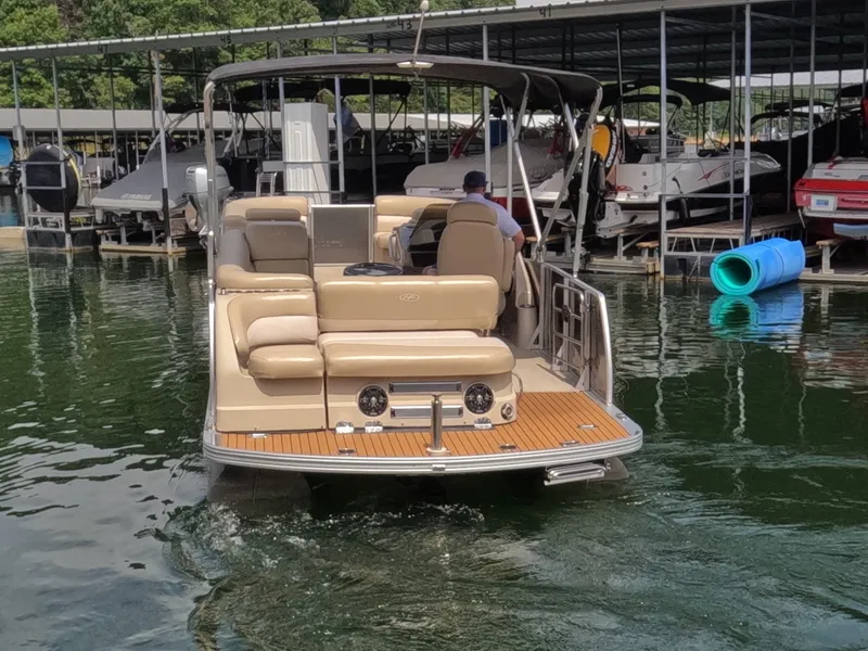 Slide: The Image of A 2013 Harris Grand Mariner 250 SEL on calm water, featuring beige upholstery and a sunshade. - 3
