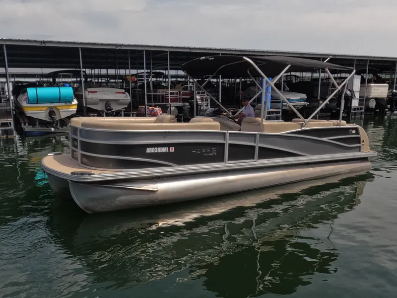 The Image of A 2013 Harris Grand Mariner 250 SEL pontoon boat is docked on the water. - 1