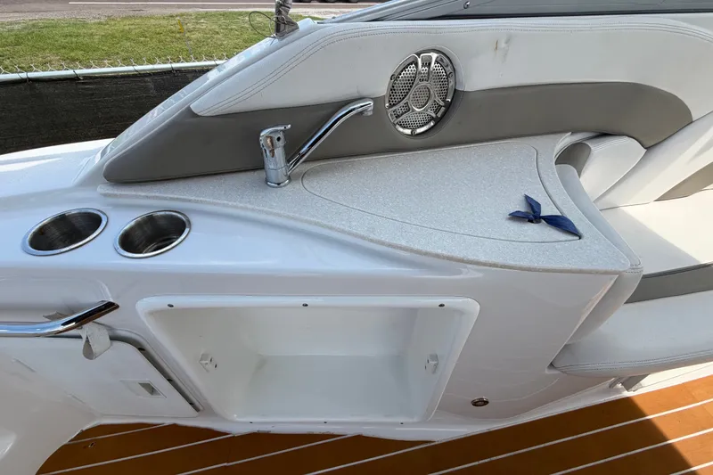 Slide: The Image of 2016 Glastron GS 259 boat interior with cup holders, faucet, and speaker. - 19