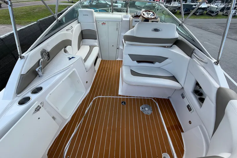 Slide: The Image of 2016 Glastron GS 259 boat interior with white seating and wood-style flooring. - 15