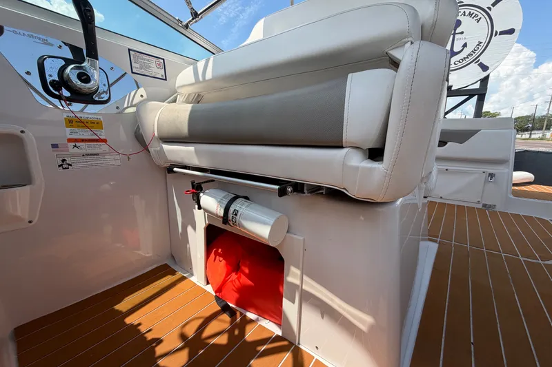 Slide: The Image of 2016 Glastron GS 259 boat interior with seating, fire extinguisher, and wooden flooring. - 78