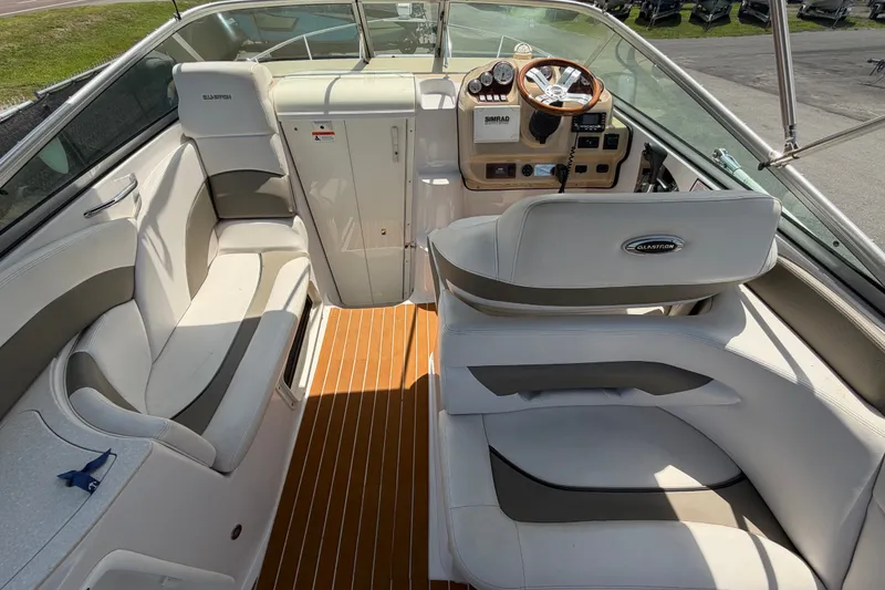 Slide: The Image of 2016 Glastron GS 259 boat interior with seating, steering wheel, and dashboard. - 22