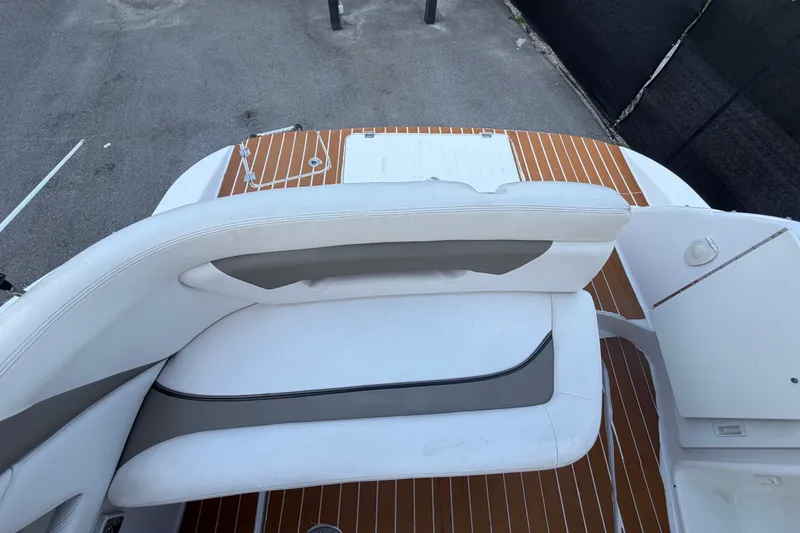 Slide: The Image of 2016 Glastron GS 259 boat interior with white seating and teak-style flooring. - 89