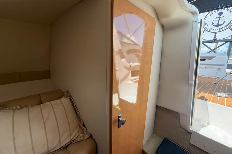 Slide: The Image of Interior cabin view of a 2016 Glastron GS 259 boat, featuring a cozy sleeping area. - 64