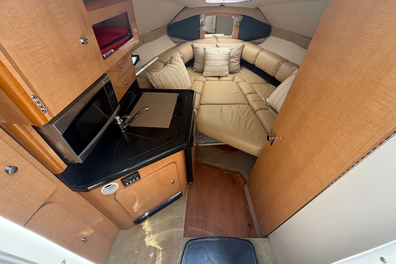 Slide: The Image of Interior of 2016 Glastron GS 259 boat with kitchenette and cozy seating area. - 40