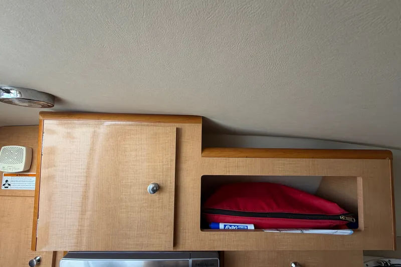 Slide: The Image of Interior of 2016 Glastron GS 259 boat with wooden cabinet and storage shelf. - 52