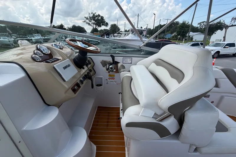 Slide: The Image of 2016 Glastron GS 259 boat cockpit with steering wheel and plush seating. - 27