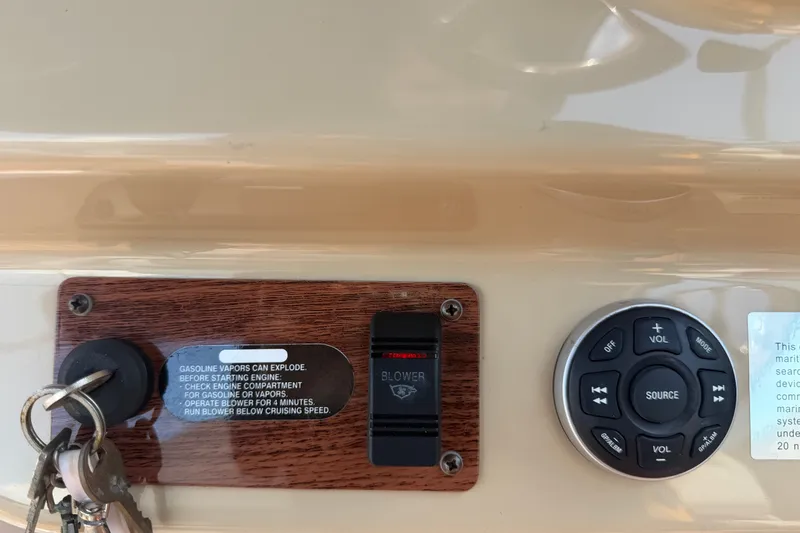 Slide: The Image of Control panel of a 2016 Glastron GS 259 boat with ignition keys and audio controls. - 36