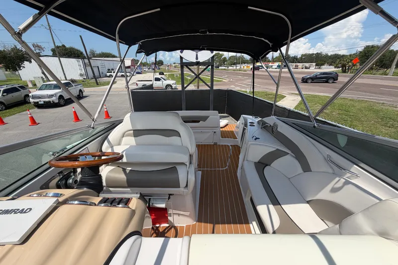 Slide: The Image of 2016 Glastron GS 259 boat interior with seating, steering wheel, and canopy. - 76