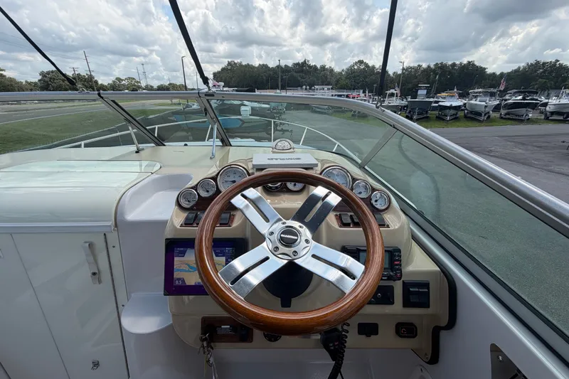 Slide: The Image of 2016 Glastron GS 259 boat dashboard with wooden steering wheel and instrument panel. - 30