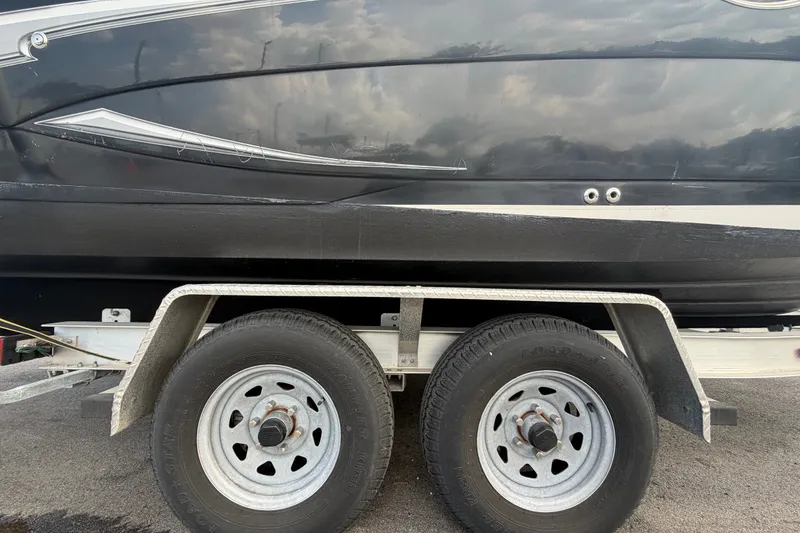 Slide: The Image of 2016 Glastron GS 259 boat on trailer, showcasing sleek black hull design. - 97