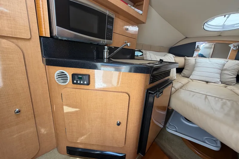 Slide: The Image of 2016 Glastron GS 259 cabin interior with kitchenette and seating area. - 49